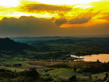 Scenic view of agricultural landscape against sky during sunset