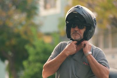 Man wearing sunglasses against trees