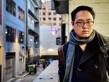 Portrait of young man standing on street in city