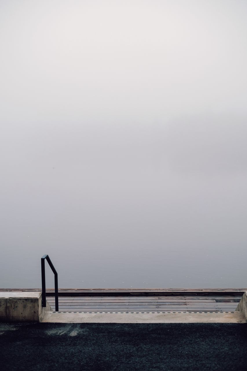 RAILING BY SEA AGAINST SKY