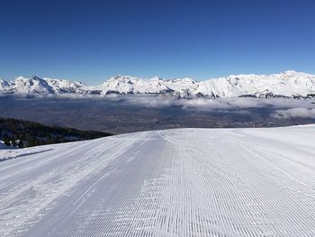 Scenic view of snowcapped mountains against clear blue sky