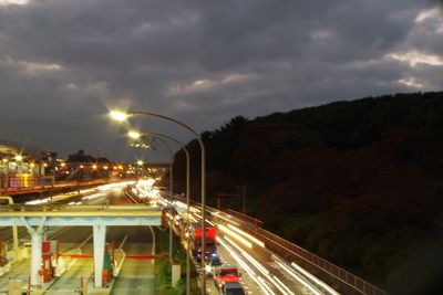 Light trails on road in city against sky at night