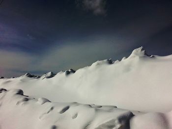 Scenic view of snow covered mountain against cloudy sky