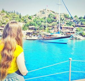 Rear view of woman standing on boat against sea