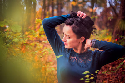 Young woman standing in forest