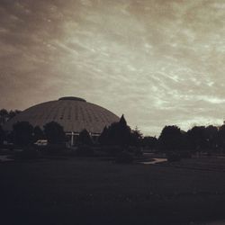 Built structure on landscape against cloudy sky