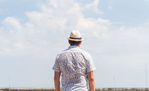 Rear view of man standing against sky