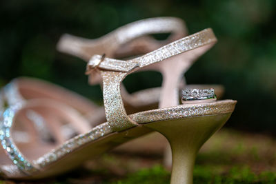 Close-up of wedding ring with sandal on field