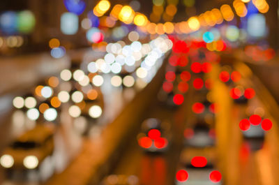 Defocused image of illuminated lights in city at night