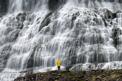 People standing against waterfall