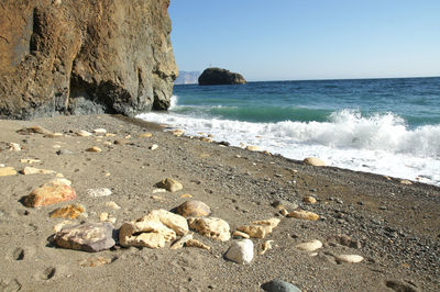 Rocks on beach against clear sky