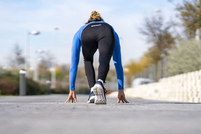 Rear view of woman with umbrella on footpath