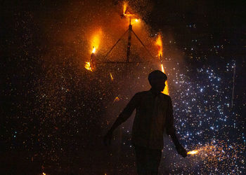 Rear view of man standing on street at night