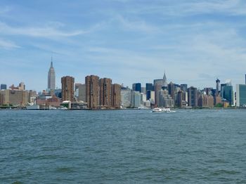 City skyline by sea against sky