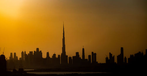 Silhouette of buildings against sky during sunset