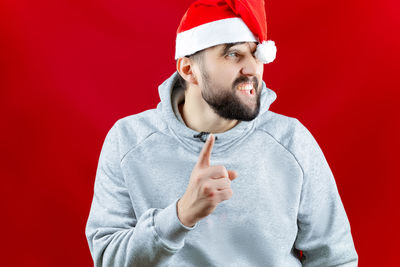 Portrait of man wearing hat against red background