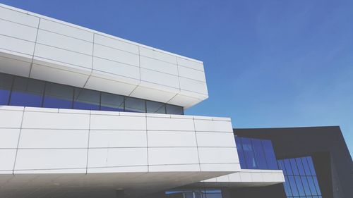 Low angle view of modern building against clear blue sky