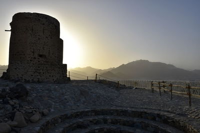 Stone structure against sky during sunset