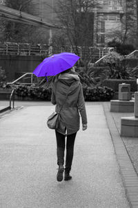 Woman with umbrella walking on wet rainy day