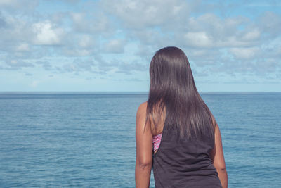 Rear view of woman looking at sea against sky