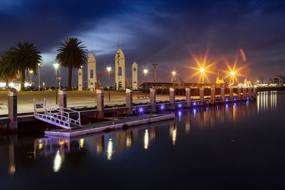 Illuminated street lights by river against sky at night geelong wsterfront