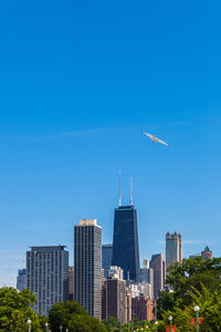 View of city buildings against blue sky