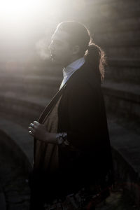 Side view of young woman standing outdoors