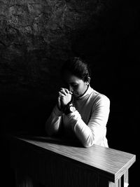 Portrait of young woman kneel in  prayer pose with rosary in hand 