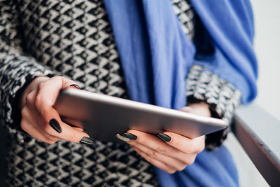 Midsection of woman using digital tablet