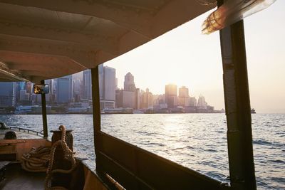 Cityscape with skyscrapers in hong kong. view from ferry on modern city at beautiful sunset.