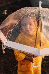 Girl holding wet umbrella during rainy season