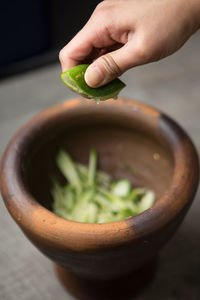 Close-up of hand squeezing lemon in bowl