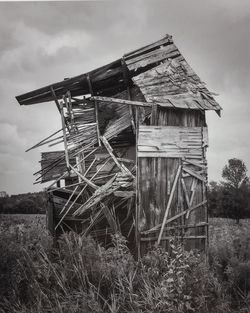 Abandoned hut on field against sky