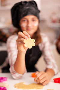 Portrait of cute girl holding cookie