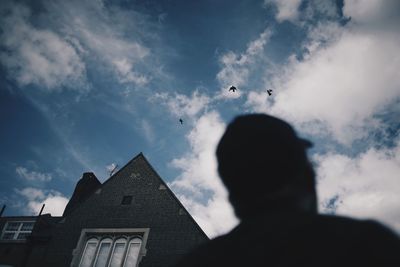 Low angle view of silhouette birds flying against sky