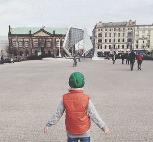 Rear view of woman standing in city