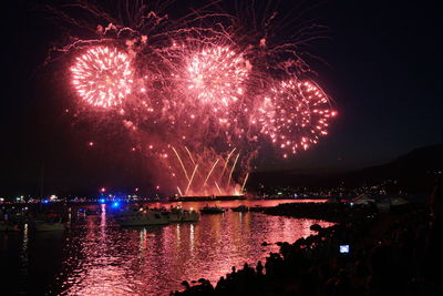 Firework display over river at night