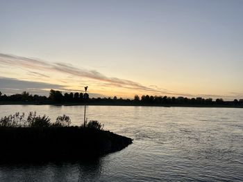 Scenic view of lake against sky during sunset