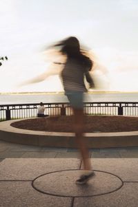 Shadow of woman standing on railing against sky