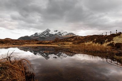 Scenic view of lake and snowcapped mountains against sky