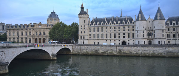 Arch bridge over river against buildings in city
