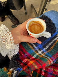 High angle view of woman holding coffee cup