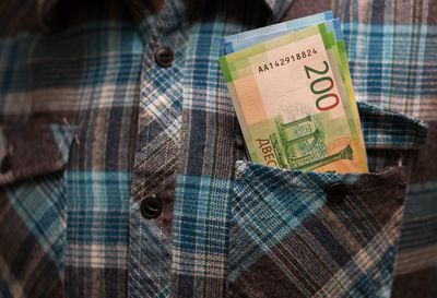 Midsection of man with paper currency in pocket