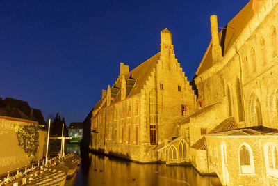 Canal amidst buildings against clear sky at night