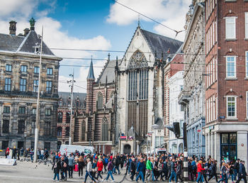 People on street against buildings in city