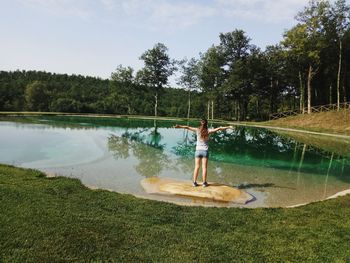 Man standing by lake against sky