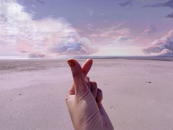 Low section of person on beach against sea