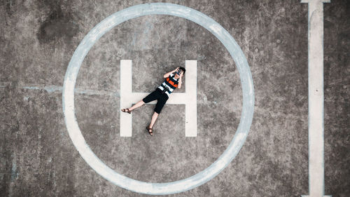 Woman with umbrella standing against the wall