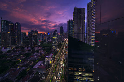 Aerial view of illuminated buildings against sky at night