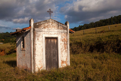 Exterior of old building on field against sky